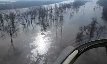 transmission line surrounded by flood waters. Flooding Awareness Month, March 2021