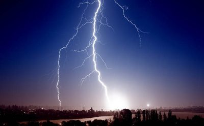 A bolt of lightning goes from cloud to ground from a dark sky.