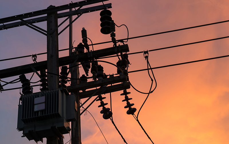 power pole in silhouette against a sunset.